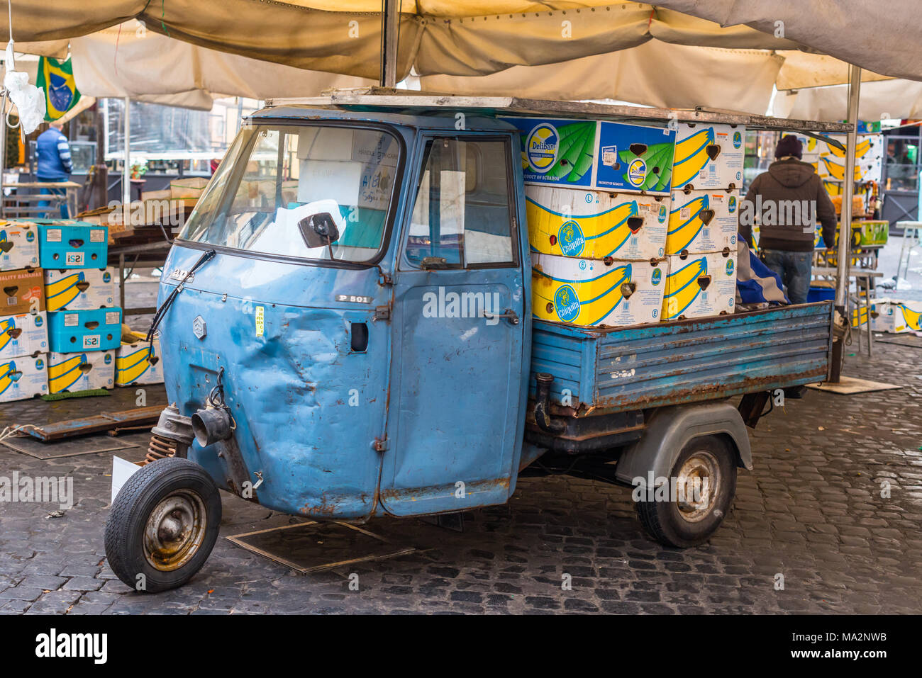 Limpieza, embalaje y cajas de carga en un Piaggo Ape 3 wheeler van al final del día, en el mercado de Campo de' Fiori, Roma, Lazio, Italia. Foto de stock