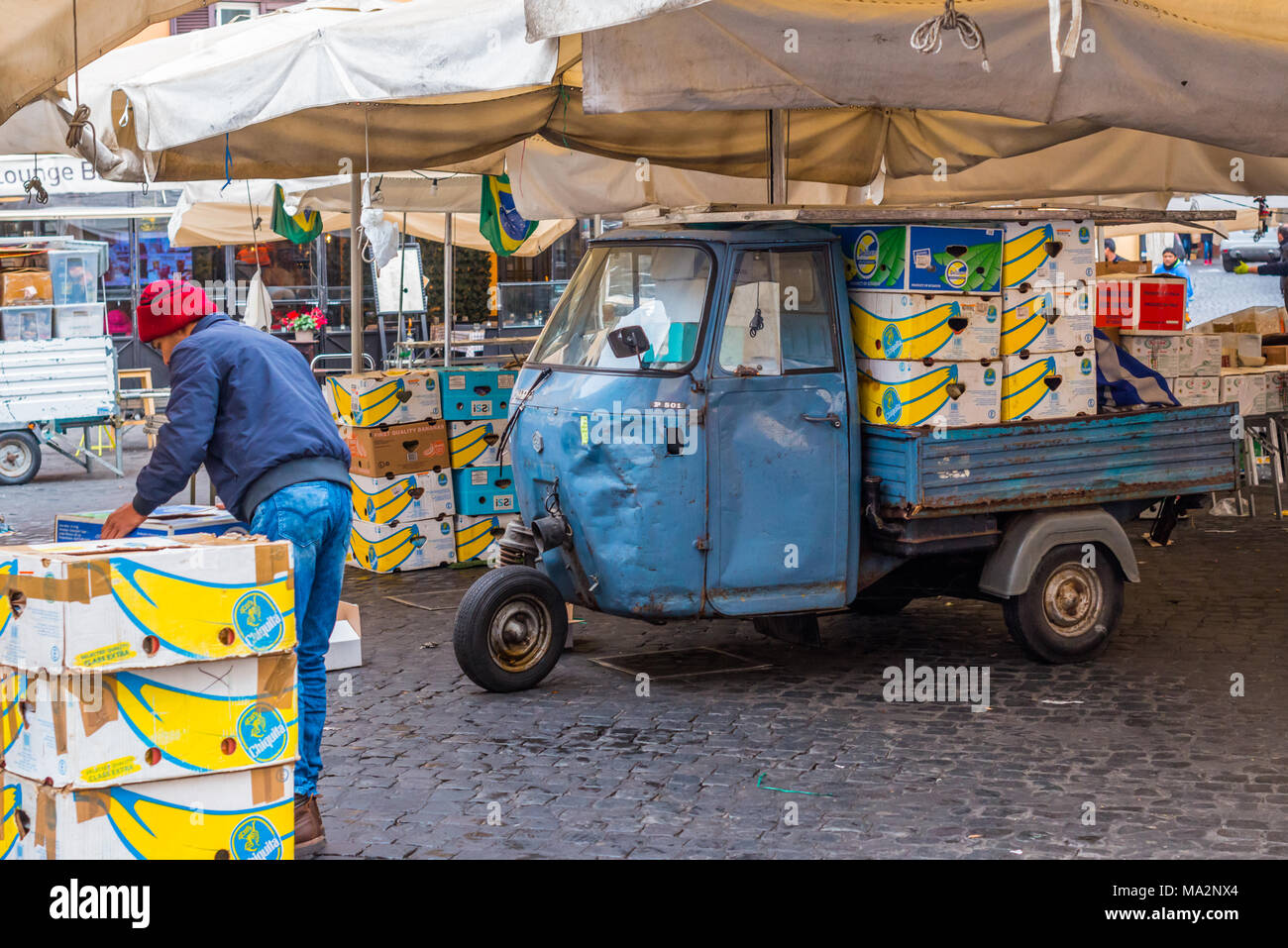 Limpieza, embalaje y cajas de carga en un Piaggo Ape 3 wheeler van al final del día, en el mercado de Campo de' Fiori, Roma, Lazio, Italia. Foto de stock