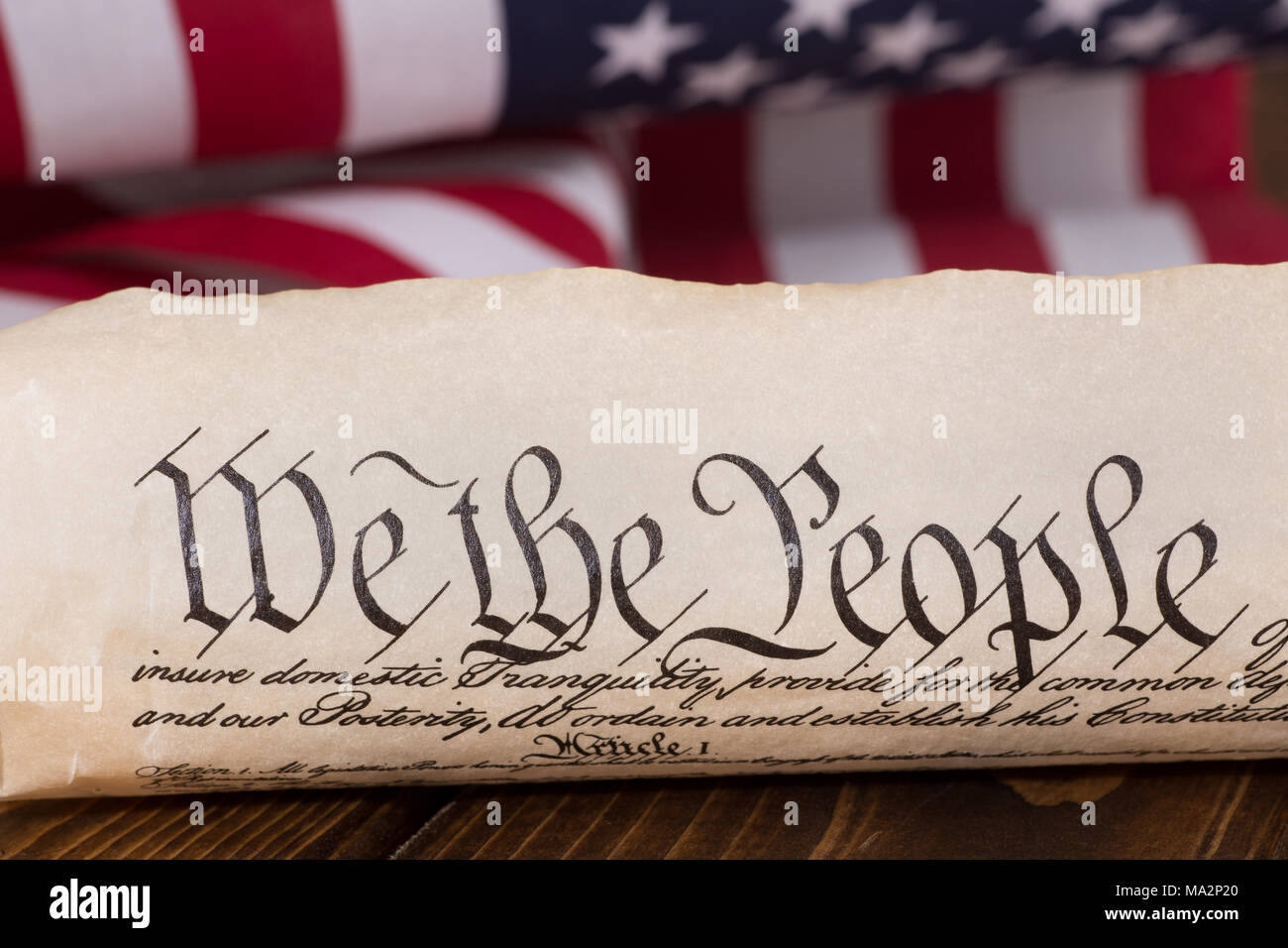 El texto del documento "Nosotros el pueblo" del preámbulo de la constitución de los Estados Unidos con la bandera americana en el fondo Foto de stock
