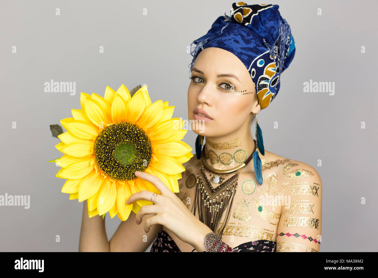 Modelo de estilo africano mujer ropa con un girasol en manos en una sesión  de fotos Fotografía de stock - Alamy