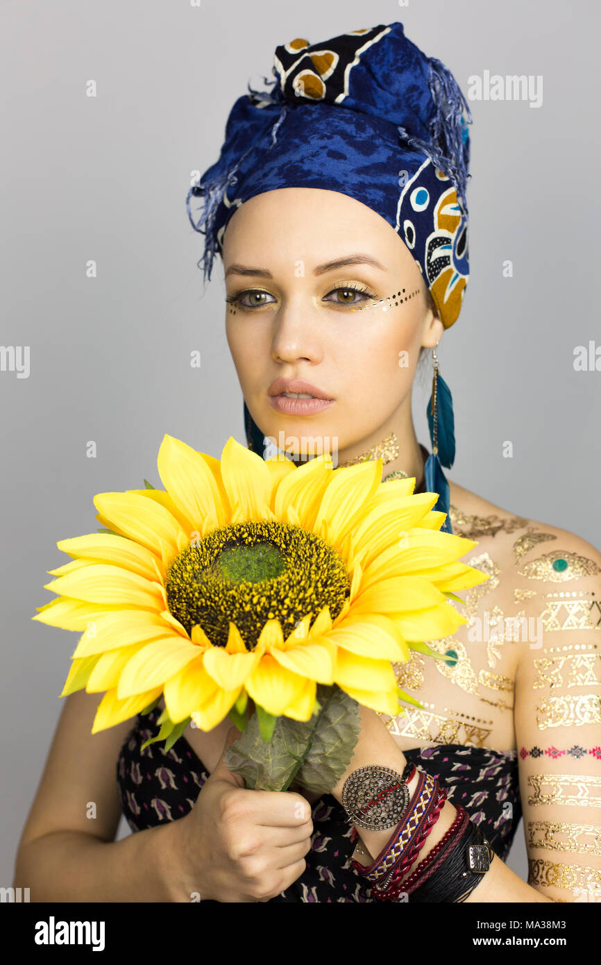 Modelo de estilo africano mujer ropa con un girasol en manos en una sesión  de fotos Fotografía de stock - Alamy