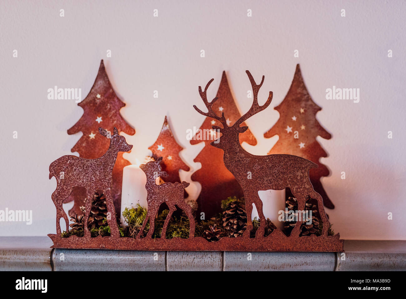 Decoración de invierno,candelabro,ciervos y abetos de la familia a la luz de las velas, Foto de stock