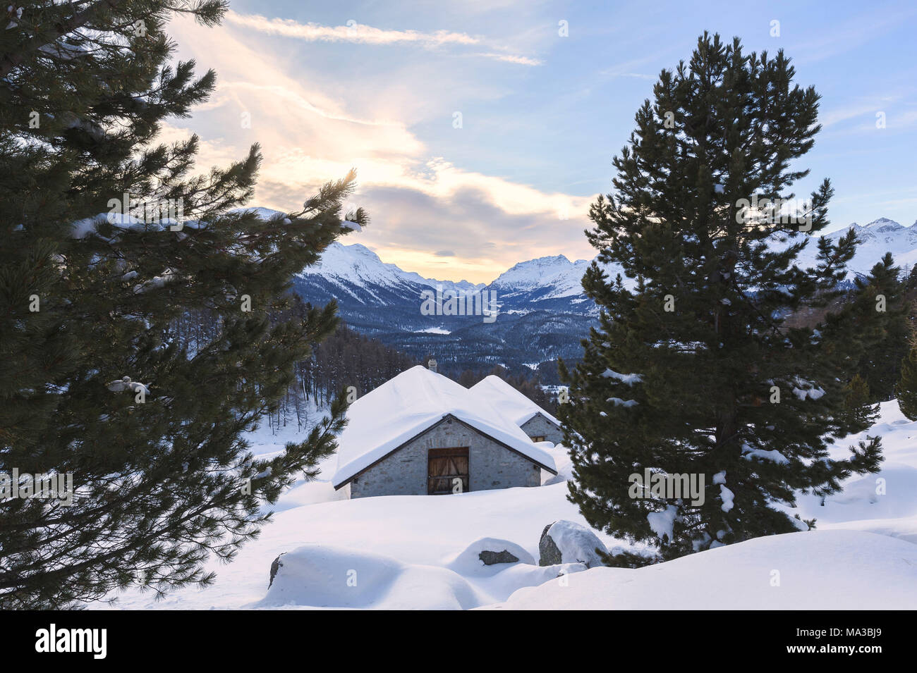 Cabañas de Alp Muragl durante la puesta de sol de invierno. Pontresina, Engadin, cantón de Los Grisones, Suiza. Foto de stock