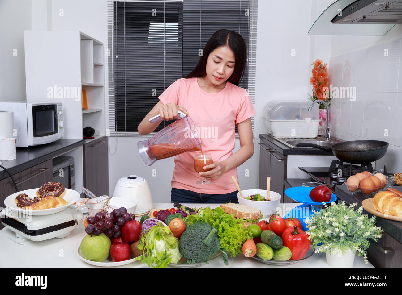 Mujer joven hacer batidos con la batidora en la cocina Mujer haciendo batidos batido con la batidora. Comer sano
