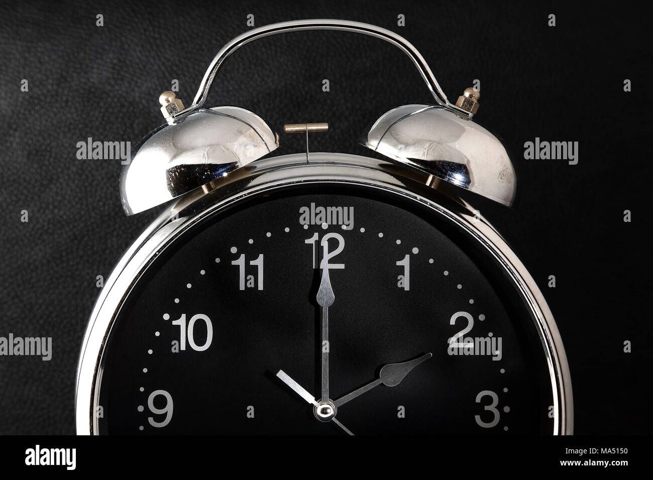 Antiguo reloj despertador retro con la hora y el minuto de manos ajustado a 2 o'clock 2 am o 2 pm aislado en un fondo negro Foto de stock