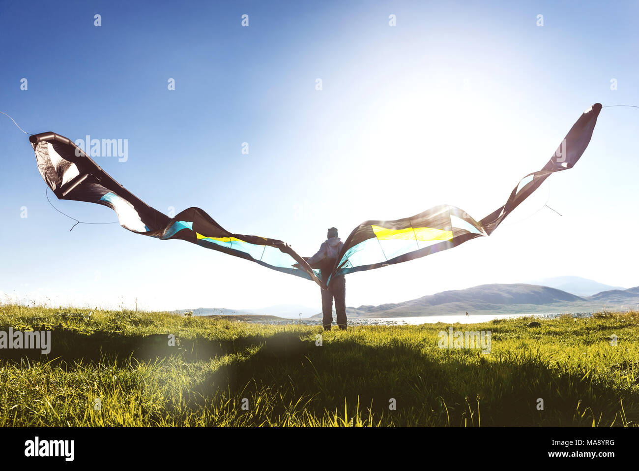 Hombre Mujer stands con kite en la luz del sol Foto de stock