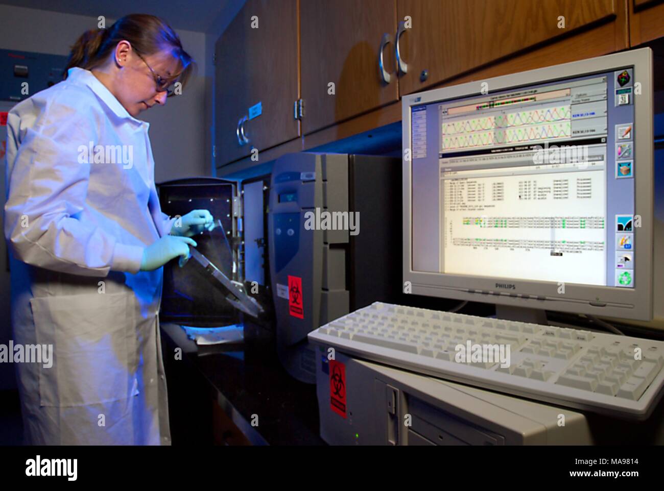 Fotografía de Amanda McNulty, un investigador en el laboratorio del CDC, trabajando en pruebas, utilizando el sistema Trugene Siemens para secuenciar el VIH, VHB y VHC en ADN para examinar su resistencia a los medicamentos antirretrovirales, como parte del programa mundial de sida, 2007. Imagen cortesía de CDC/Hsi Liu, James Gathany. () Foto de stock