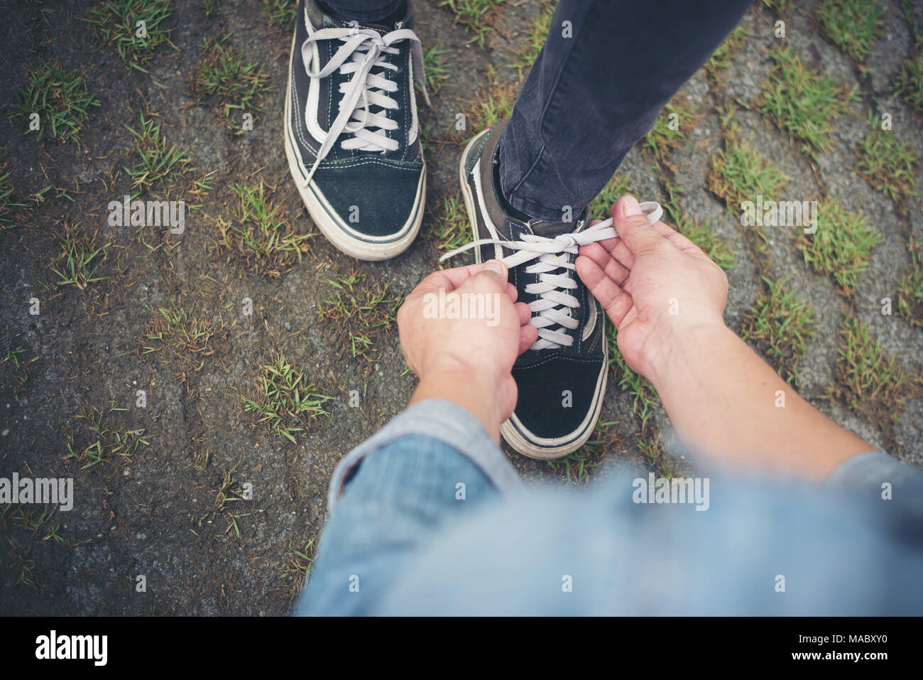 Hipster novio zapatos atado a sus niñas mientras vaya al relajarse en  vacaciones, una pareja en concepto de amor Fotografía de stock - Alamy