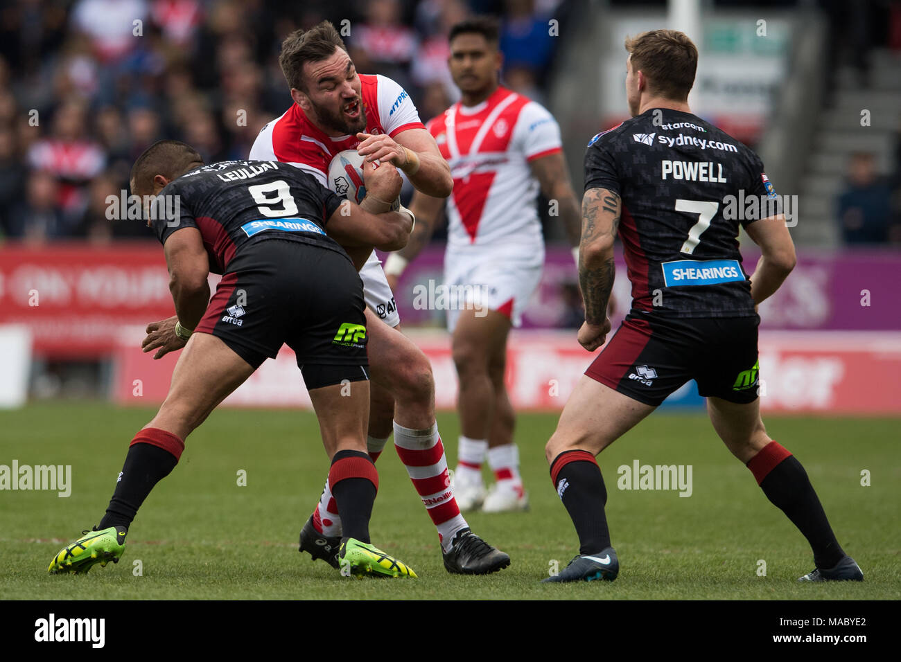 Santa Helena es Lucas Douglas es abordada por Wigan Warriors Thomas Leuluai 30 Marzo 2018 , totalmente malvados Stadium, Merseyside, Inglaterra; Betfred Super Foto de stock