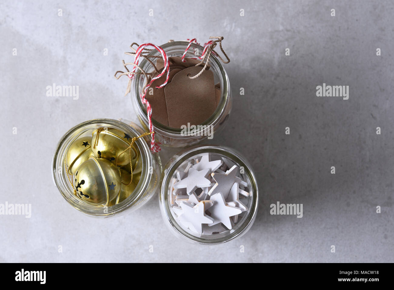 Regalo de navidad envolver los suministros. Mason tres frascos con etiquetas de regalo, madera, estrellas, campanas y trineos con espacio de copia. Foto de stock