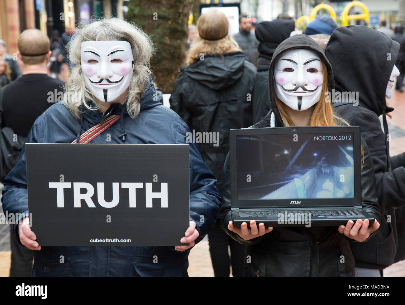 Un grupo de activistas de los derechos de los animales en el centro de la ciudad de Birmingham, Inglaterra. El tipo de Guy Fawkes llevaban máscaras y portaban carteles con la palabra "verdad" Foto de stock