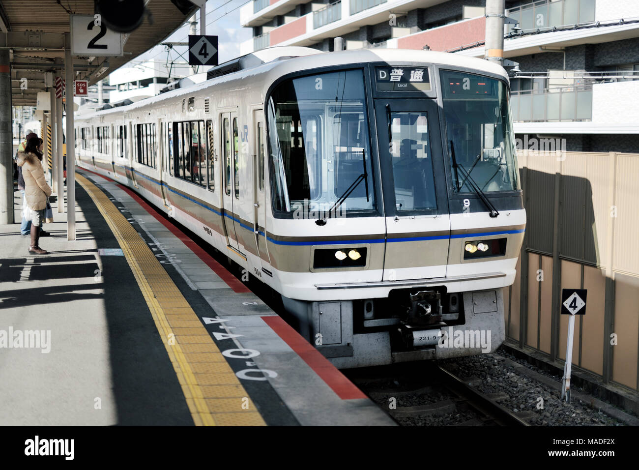El tren JR para llegar a una estación de tren plataforma en Kioto, Japón, 2017 Foto de stock