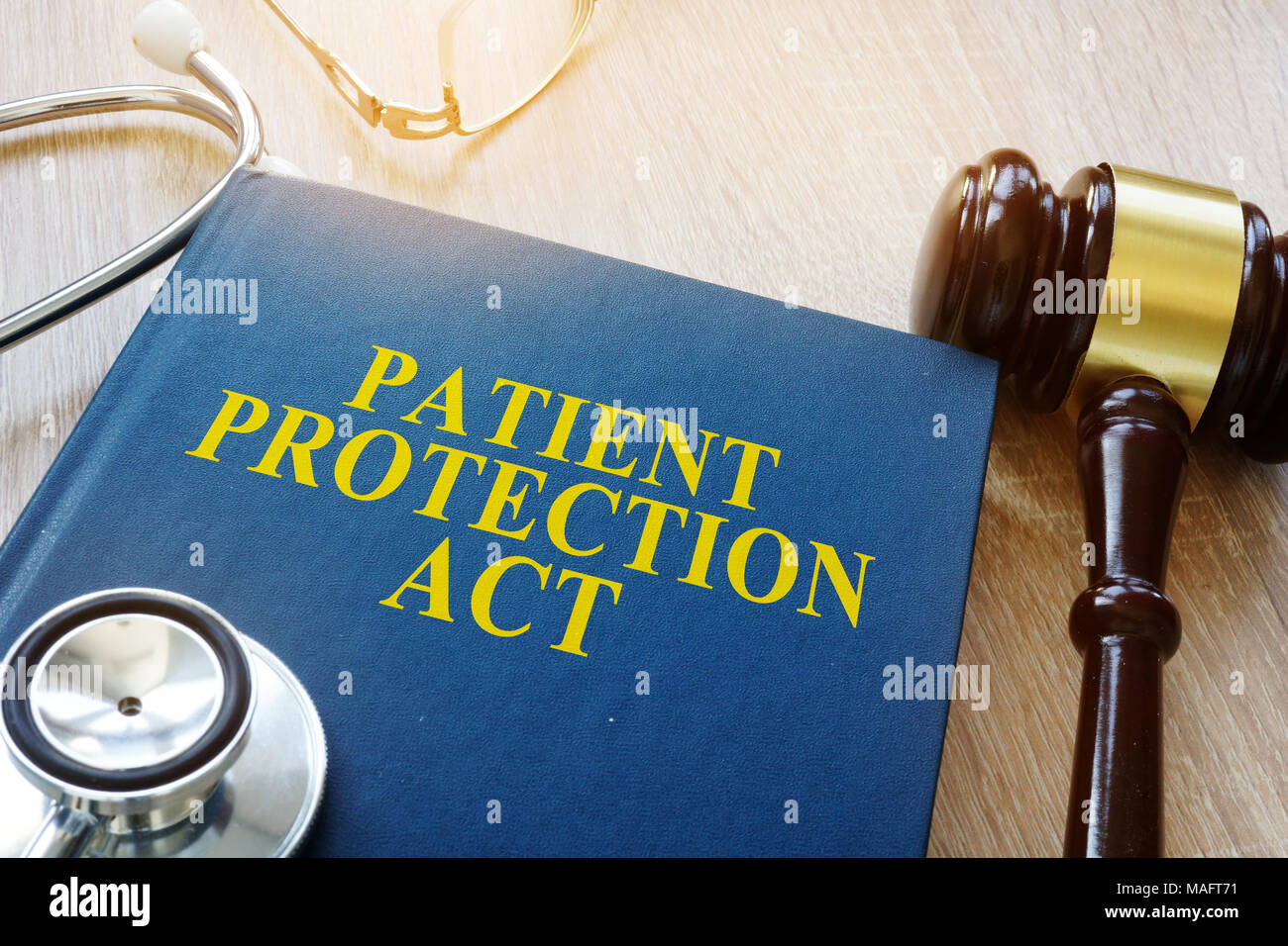 Ley de protección del paciente y el martillo sobre una mesa. Foto de stock