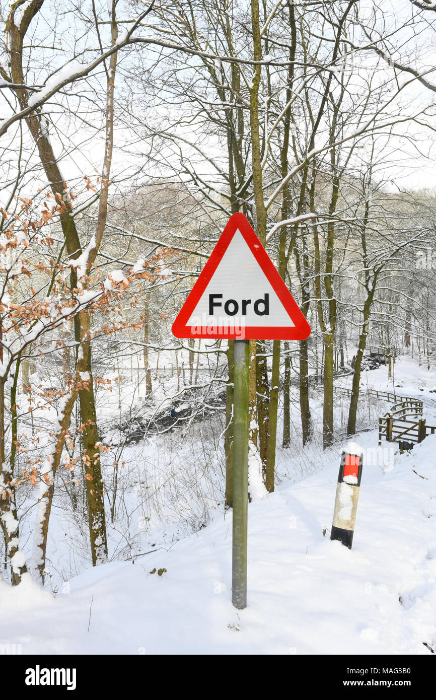 Señal de advertencia de Ford por río wharfe fluyendo a través del paisaje invernal en el Bolton Abbey wharfedale Yorkshire Dales reino unido Foto de stock