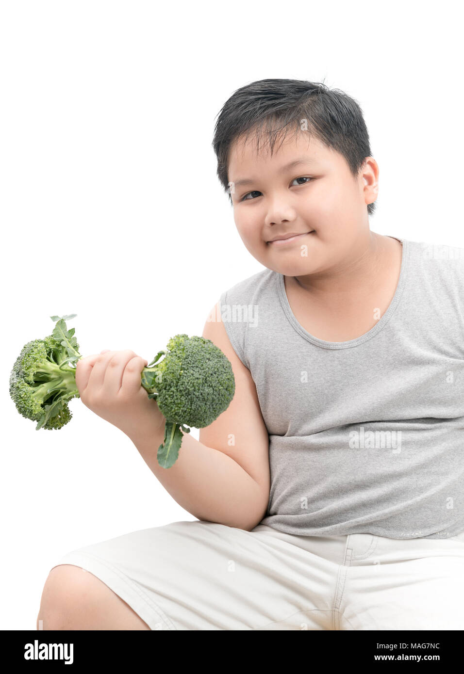 Obeso Fat Boy sosteniendo un brócoli pesa aislado sobre fondo blanco, la dieta y el ejercicio para la buena salud, concepto Foto de stock