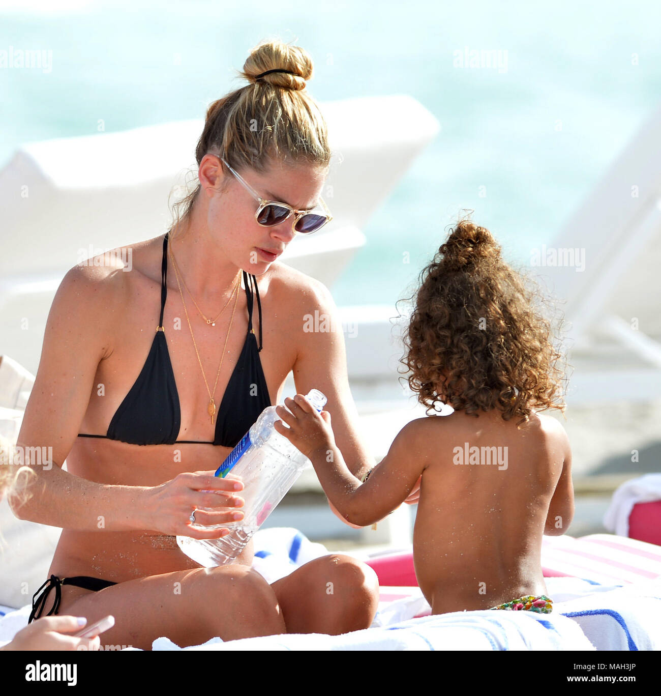 MIAMI, FL - 03 de enero: Doutzen Kroes, la ex Ángel de Victoria's Secret,  vistiendo un diminuto bikini string triángulo negro se unió a su adorable  niños, hijo Phyllon, cinco, y su