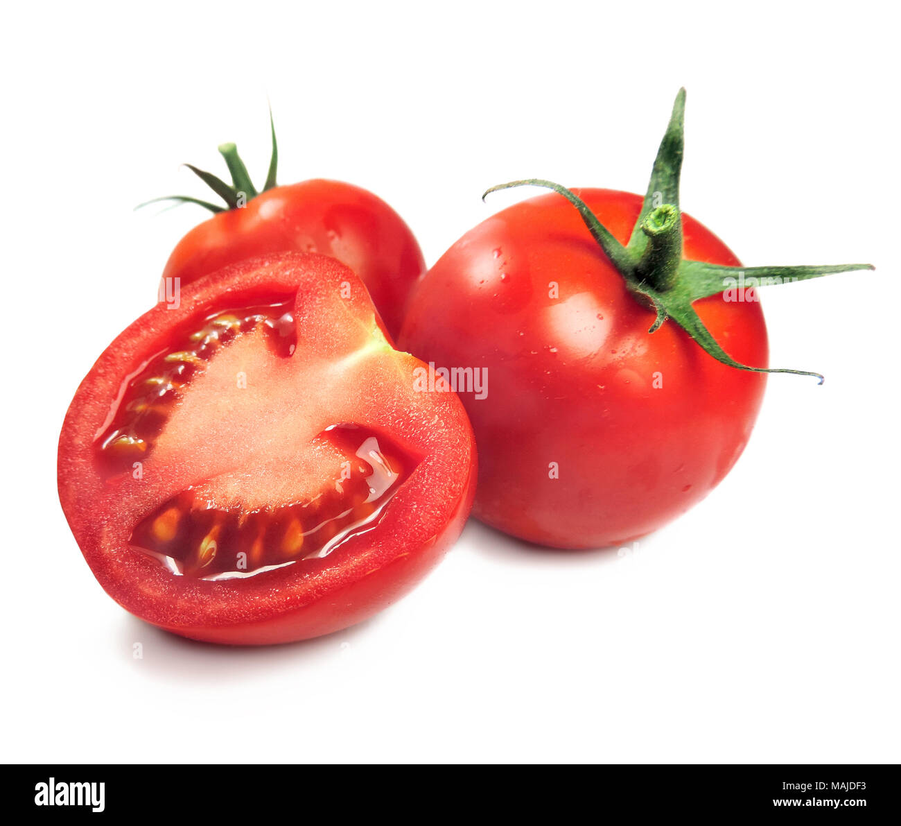 Tomates maduros o tomates cherry, aislado sobre fondo blanco. Rodaja de tomate fresco y zapata tomates en blanco. Ingredientes de cocina. Foto de stock