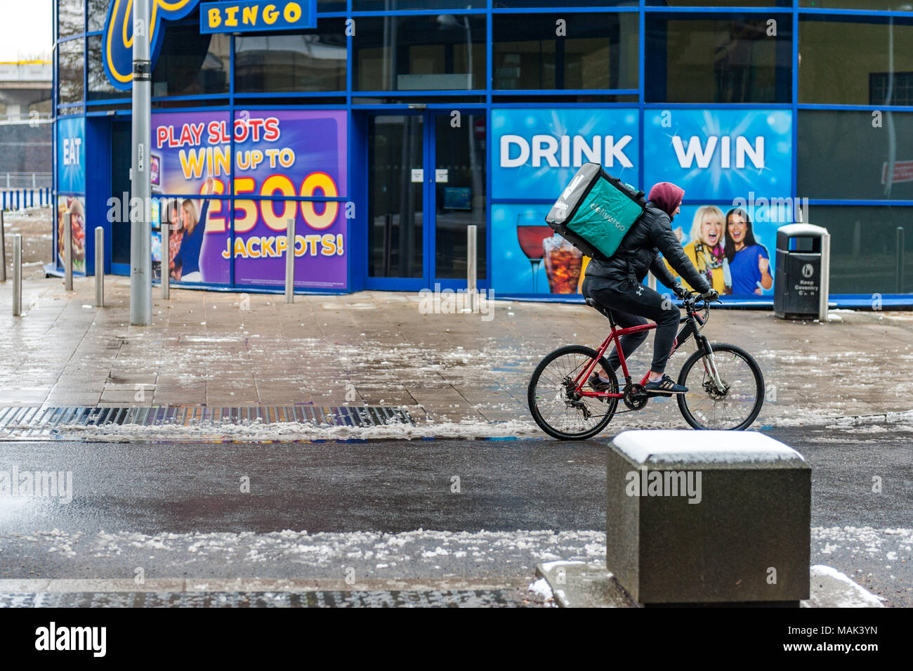 Entrega Deliveroo Deliveroo rider con una caja de Alimentos sobre sus espaldas cabalgando por Fairfax Street, Coventry, West Midlands, Reino Unido. Foto de stock