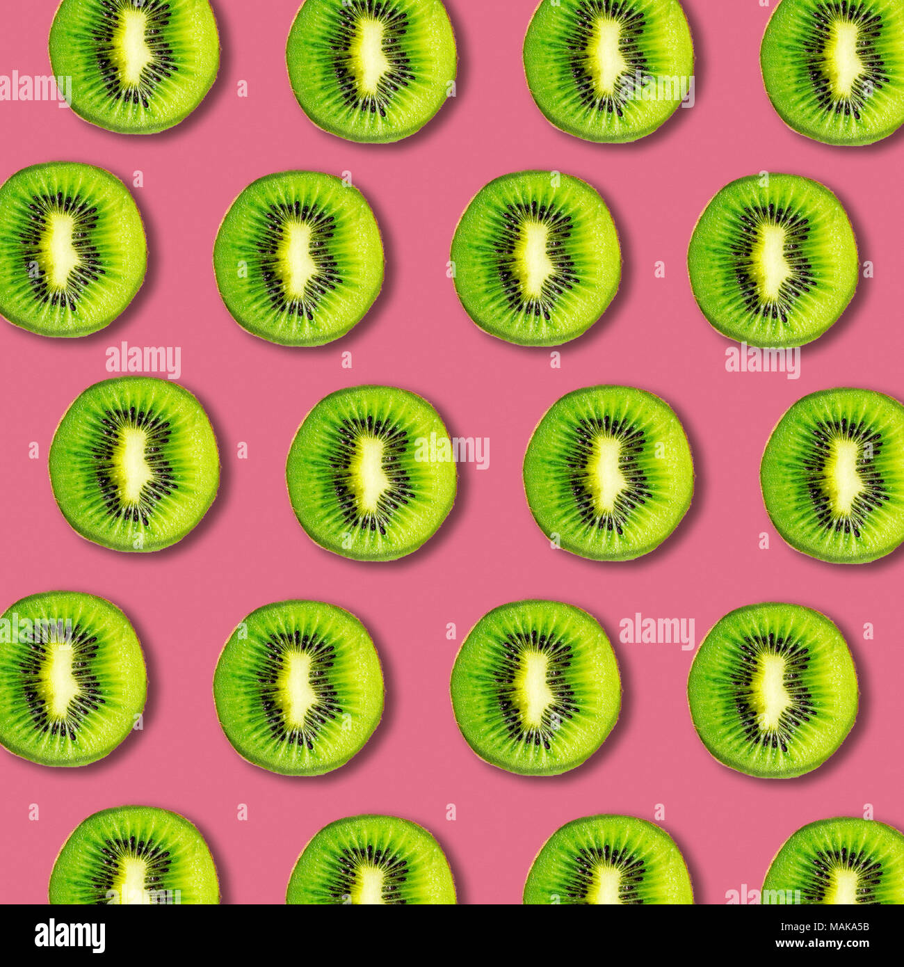 El Kiwi rebanadas patrón sobre fondo de color vibrante. Textura Alimentos laicos fija mínima Foto de stock