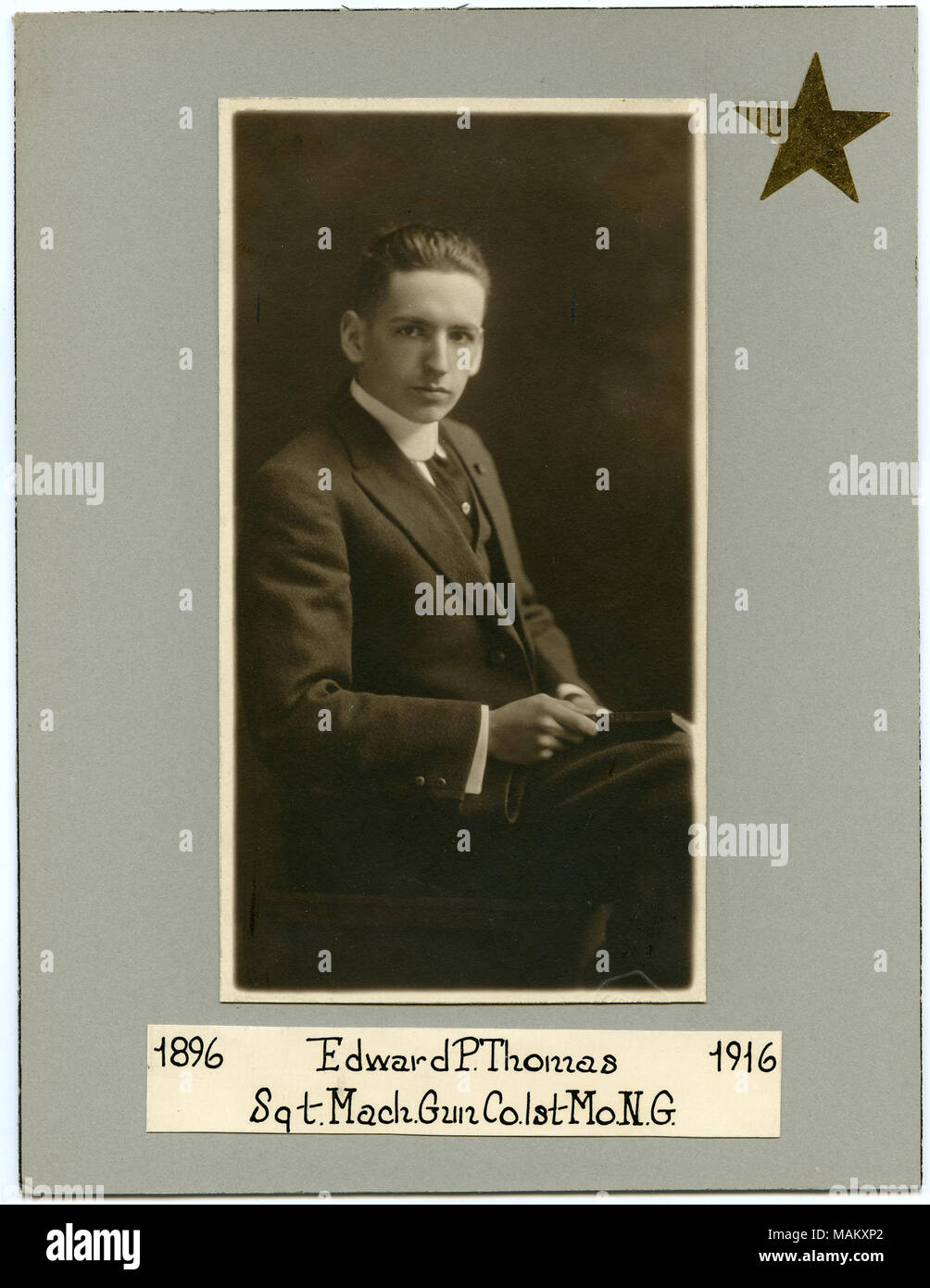 Fotografía en blanco y negro de un hombre sentado en un traje y corbata. Inscripción dice '1896 / Edward P. Thomas / 1916 / Sgt. Mach. Gun Co. 1Mo. N.G.' de la fotografía de oro mate tiene un adhesivo en forma de estrella en la esquina superior derecha. Título: Edward P. Thomas (1896-1916), sargento, ametralladoras, 1ª Compañía de la Guardia Nacional de Missouri . circa 1916. Foto de stock