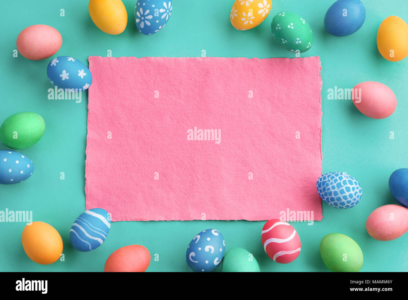 ¡Felices Pascuas de Resurrección! Fondo turquesa con coloridos huevos de pascua. Vista superior con espacio de copia. Foto de stock