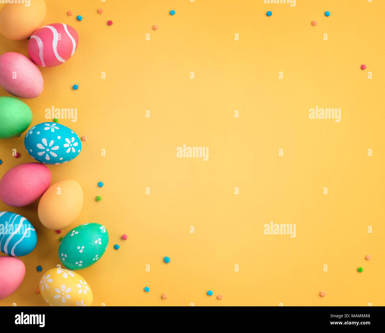 ¡Felices Pascuas de Resurrección! Fondo amarillo con coloridos huevos de pascua. Vista superior con espacio de copia. Foto de stock