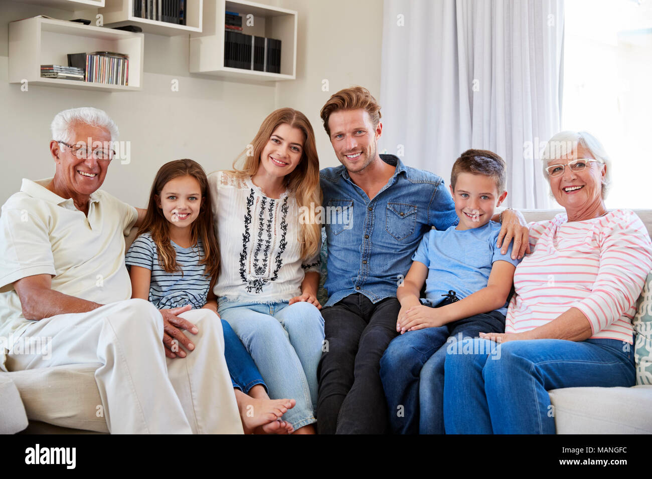 Retrato de familia de generación múltiple sentado en un sofá en casa Foto de stock