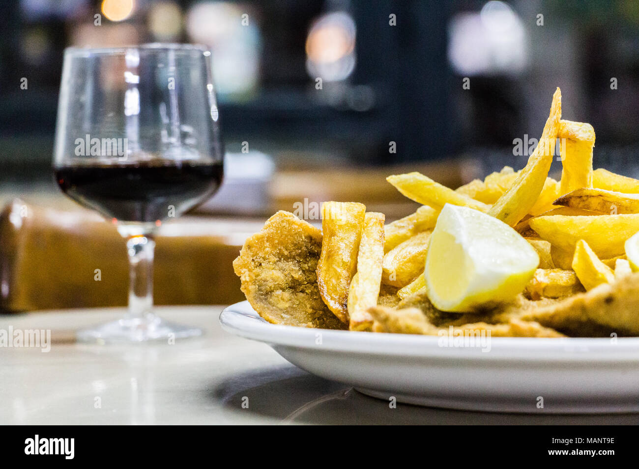 Un plato de Milanesas con papas fritas (schnitzel hecha con carne de vaca y papas fritas) sobre una mesa de madera en un pequeño restaurante para los trabajadores en Buenos Foto de stock