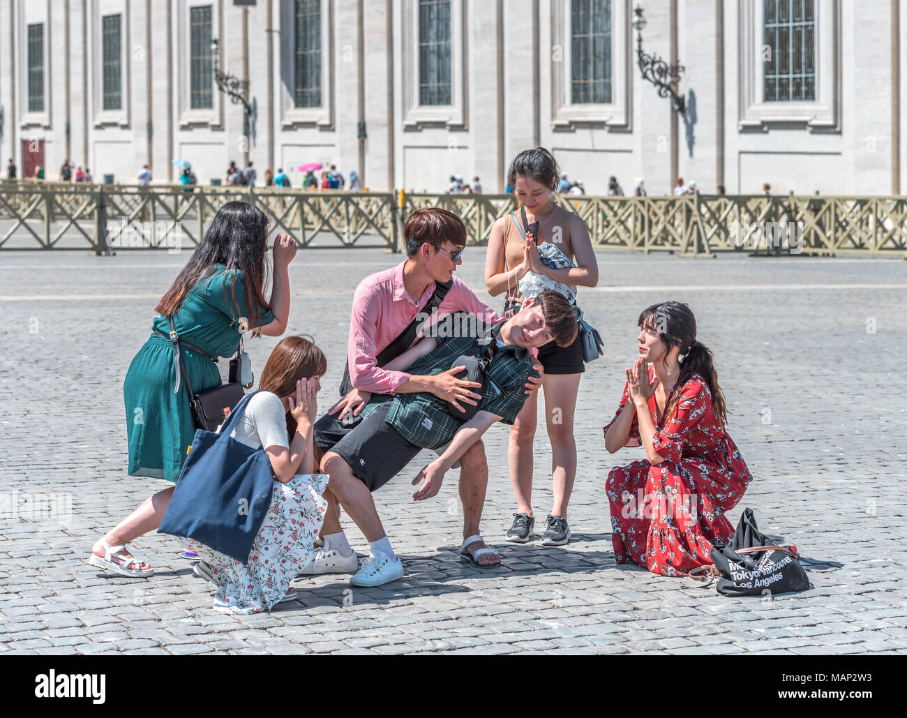 Un grupo de jóvenes chinos divirtiéndose en la plaza de San Pietro. Foto de stock