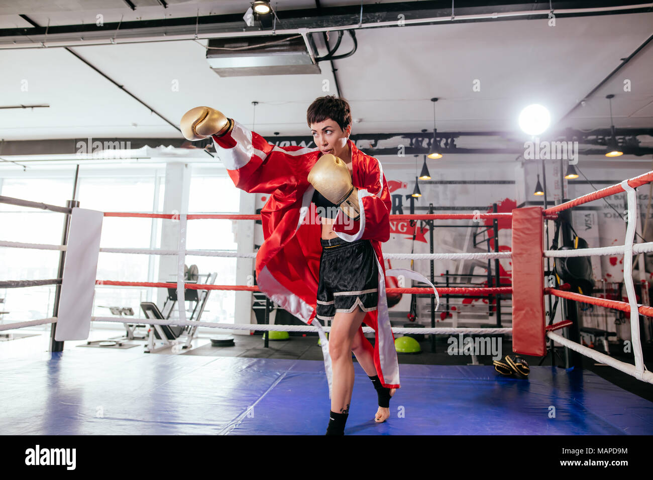 Hermoso modelo combates con el oponente en amarillo guantes de boxeo en anillo sparring Foto de stock