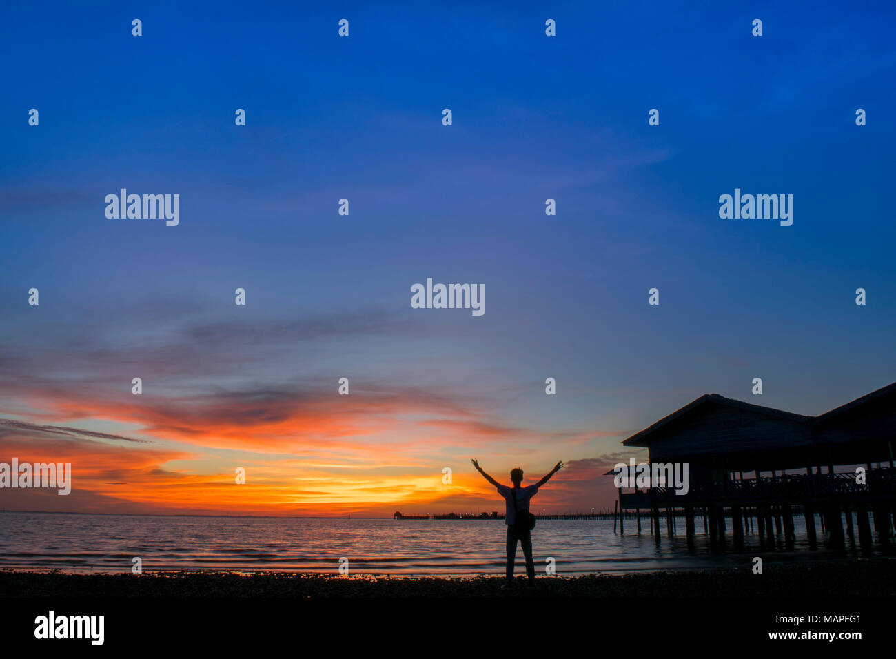 Silueta hombre en la playa contra el ocaso - La isla de Bintan, Indonesia Foto de stock