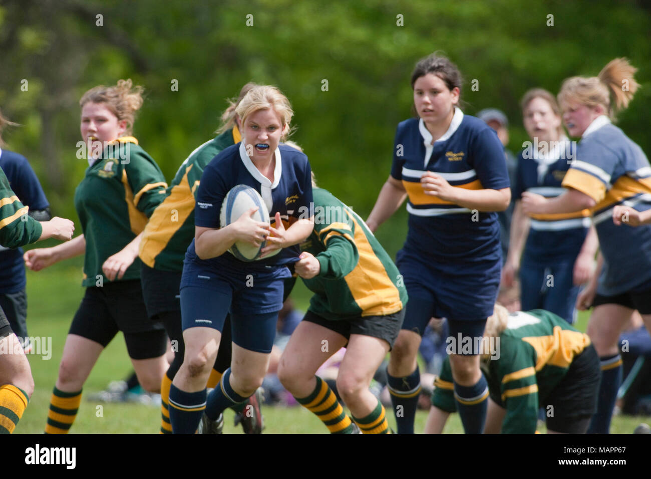 Chica corriendo con la bola en el partido de rugby Foto de stock