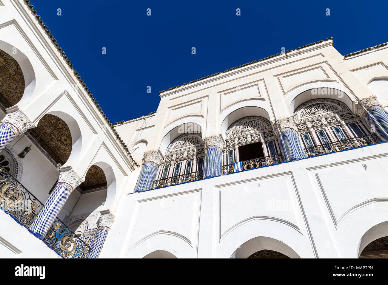 Detalle de la arquitectura oriental de un palacio marroquí, con arcos, columnas y decoraciones de mosaicos, el Palacio de El Mokri, en Fes, Marruecos Foto de stock
