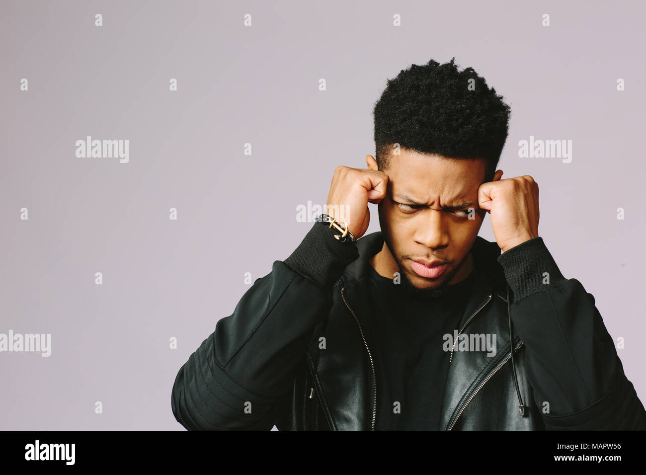 Retrato de un joven enojado y deprimido, aislado sobre fondo studio Foto de stock