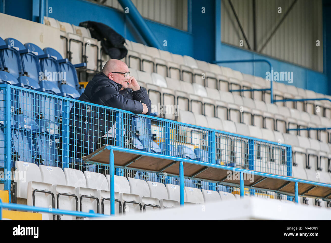 Solitario simpatizante de fútbol sentado en las gradas de hablar en el teléfono. Foto de stock
