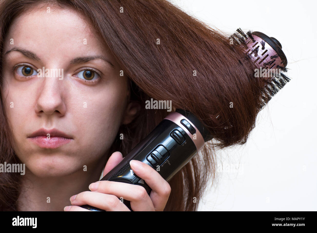 Una pelirroja modelo usando un cepillo moldeador de aire en su cabello  Fotografía de stock - Alamy