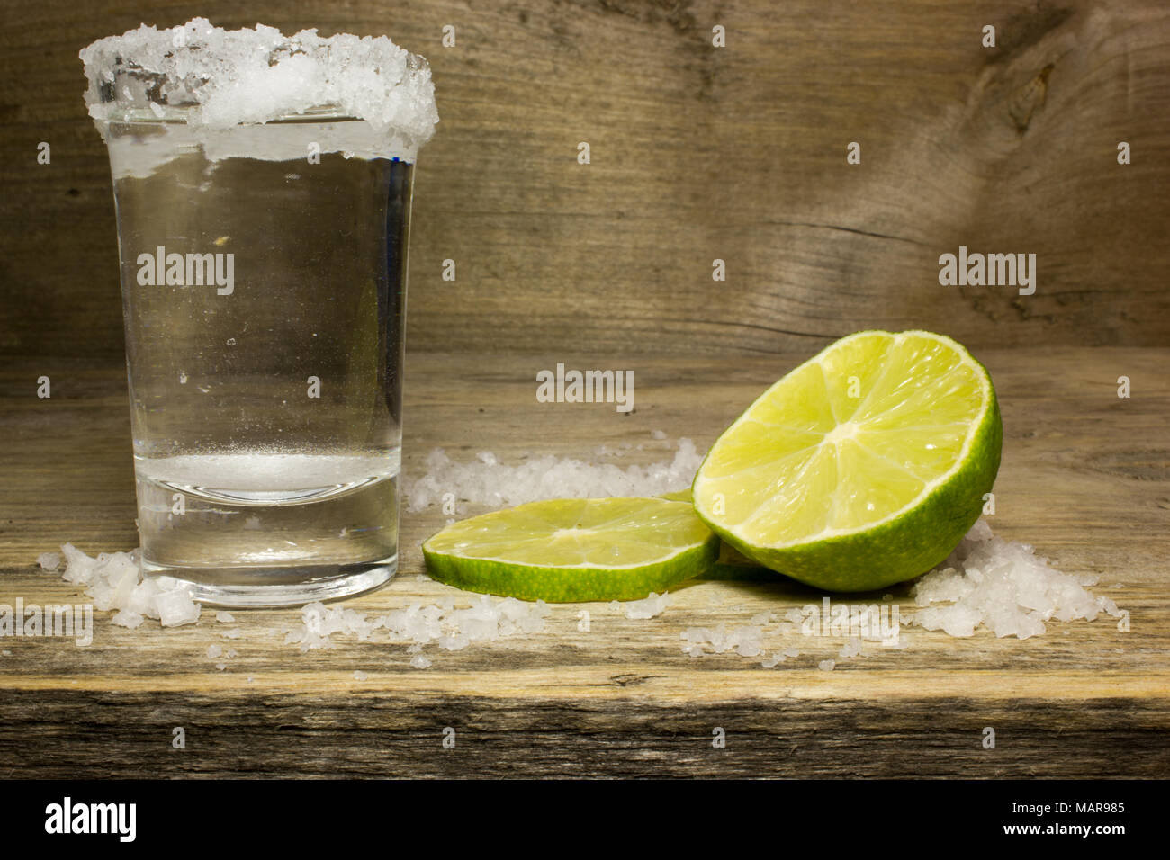 eficientemente Jarra Que pasa El Tequila en un vaso de vidrio con tajadas de limón y sal Fotografía de  stock - Alamy