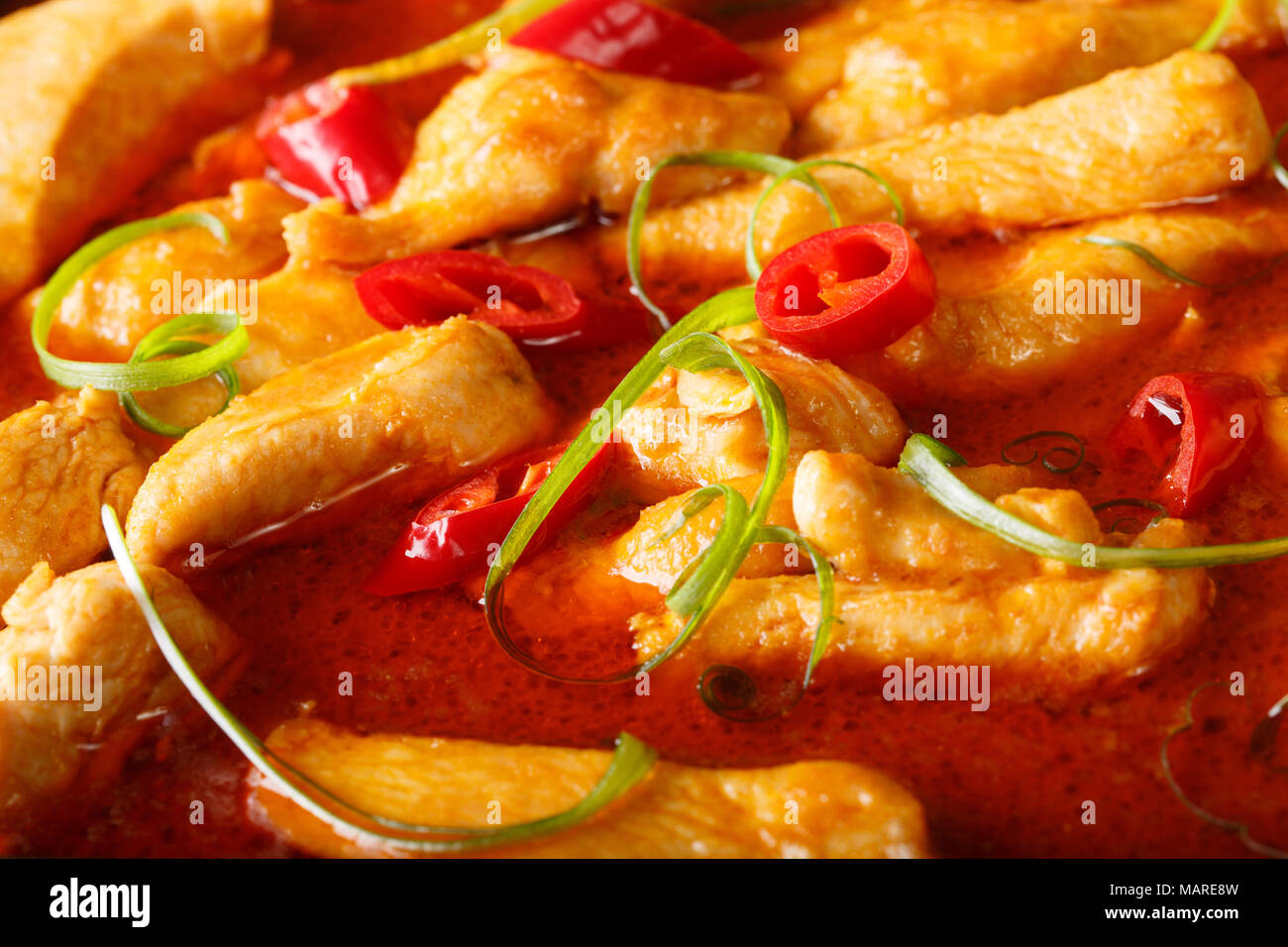 Comida tailandesa de la calle: pollo al curry panang macro horizontal de fondo. Foto de stock