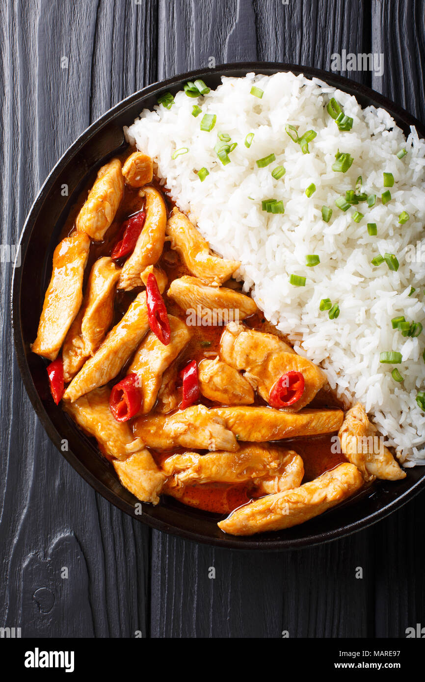 Curry panang de pollo con guarnición de arroz cerca en una placa. Vista superior de la vertical desde arriba Foto de stock