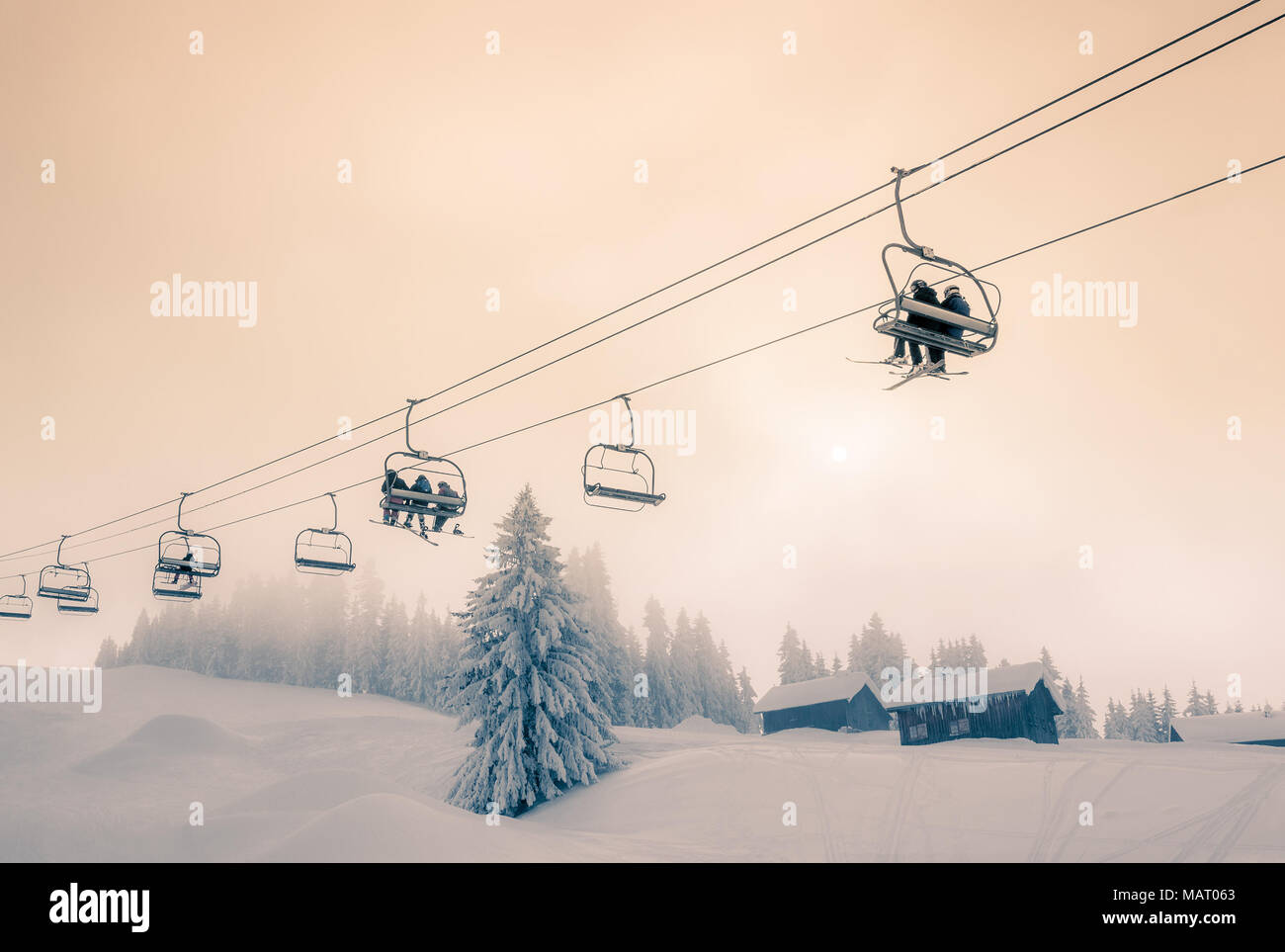 Los esquiadores y snowboarders de Nieve viaja en un telesilla en Morzine Ski Resort en Francia. Dividir tonos del tratamiento. Foto de stock