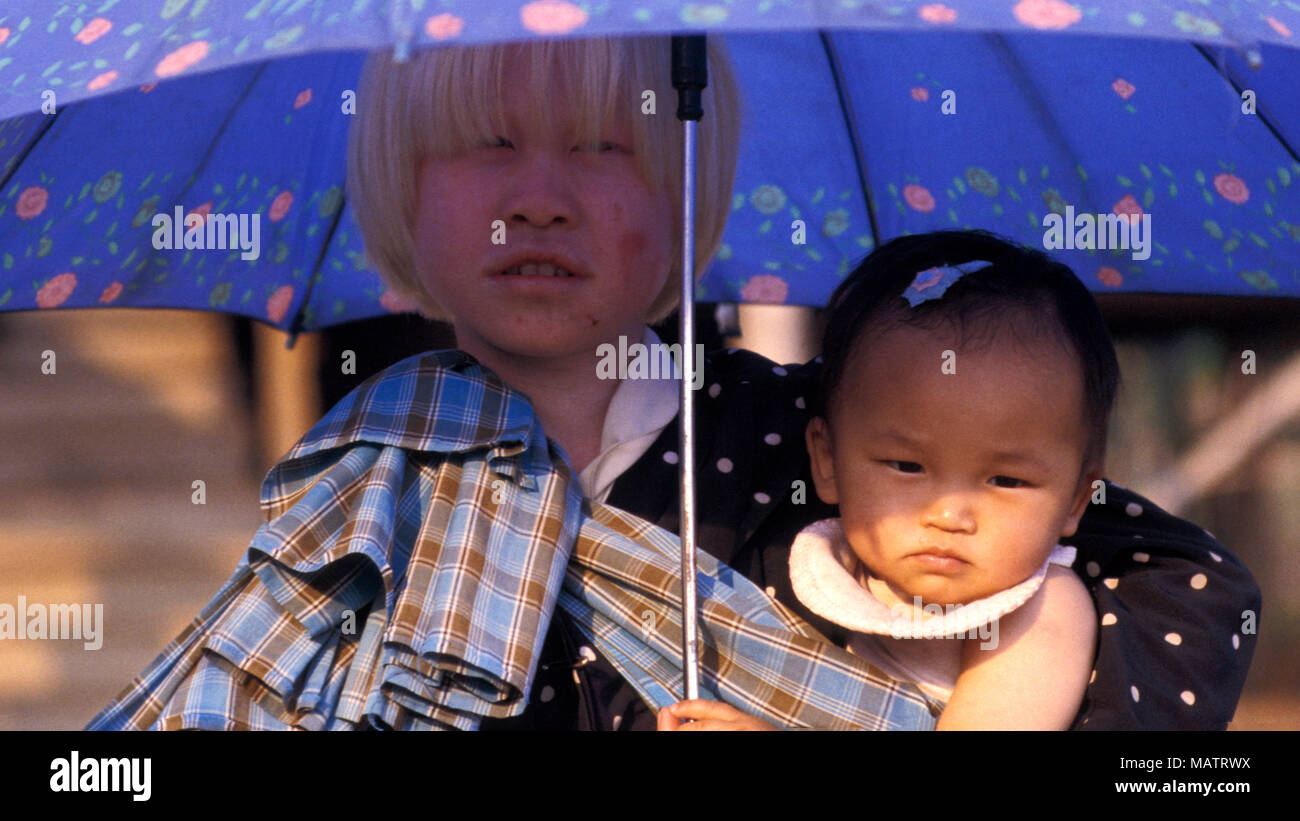 Un indígena albino chica de Birmania es una remota tribu protege a ella y a su hermana del sol con una sombrilla Fotografía stock Alamy