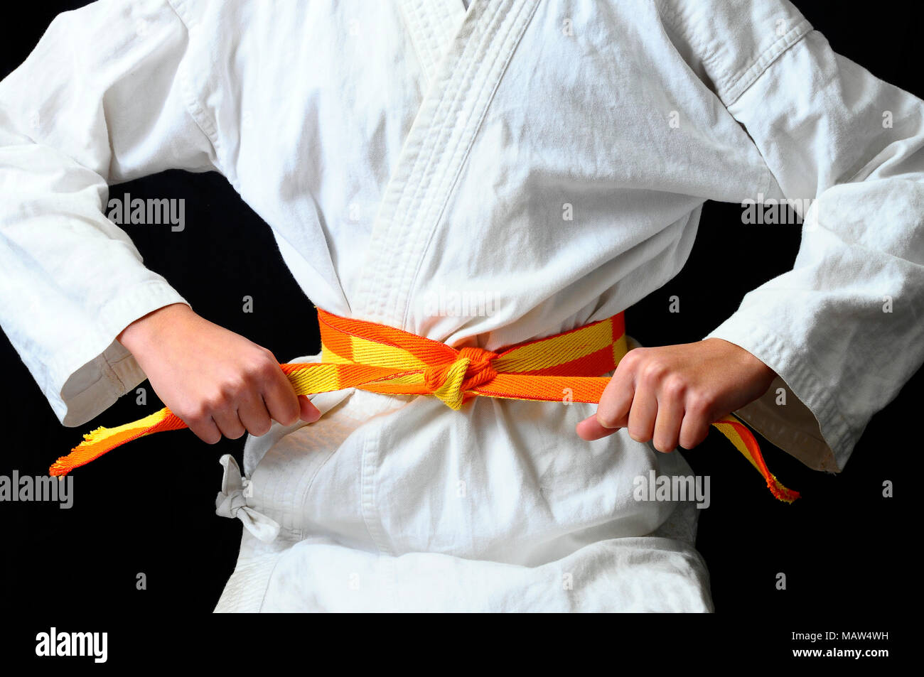Las manos del niño haciendo un arco sobre naranja amarillo cinturón de  Karate Shotokai Fotografía de stock - Alamy