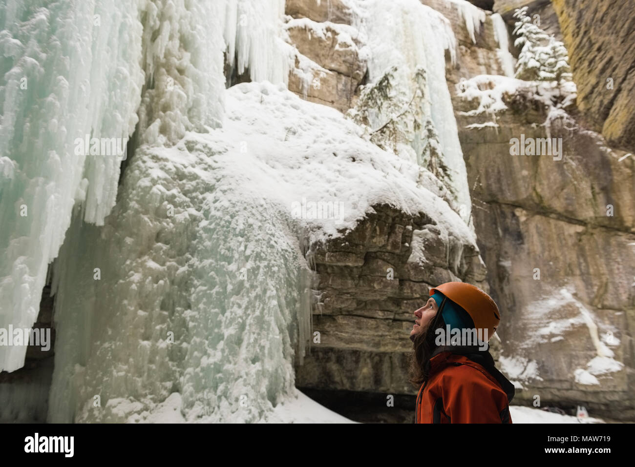 Escalador hembra mirando a Rocky ice mountain Foto de stock