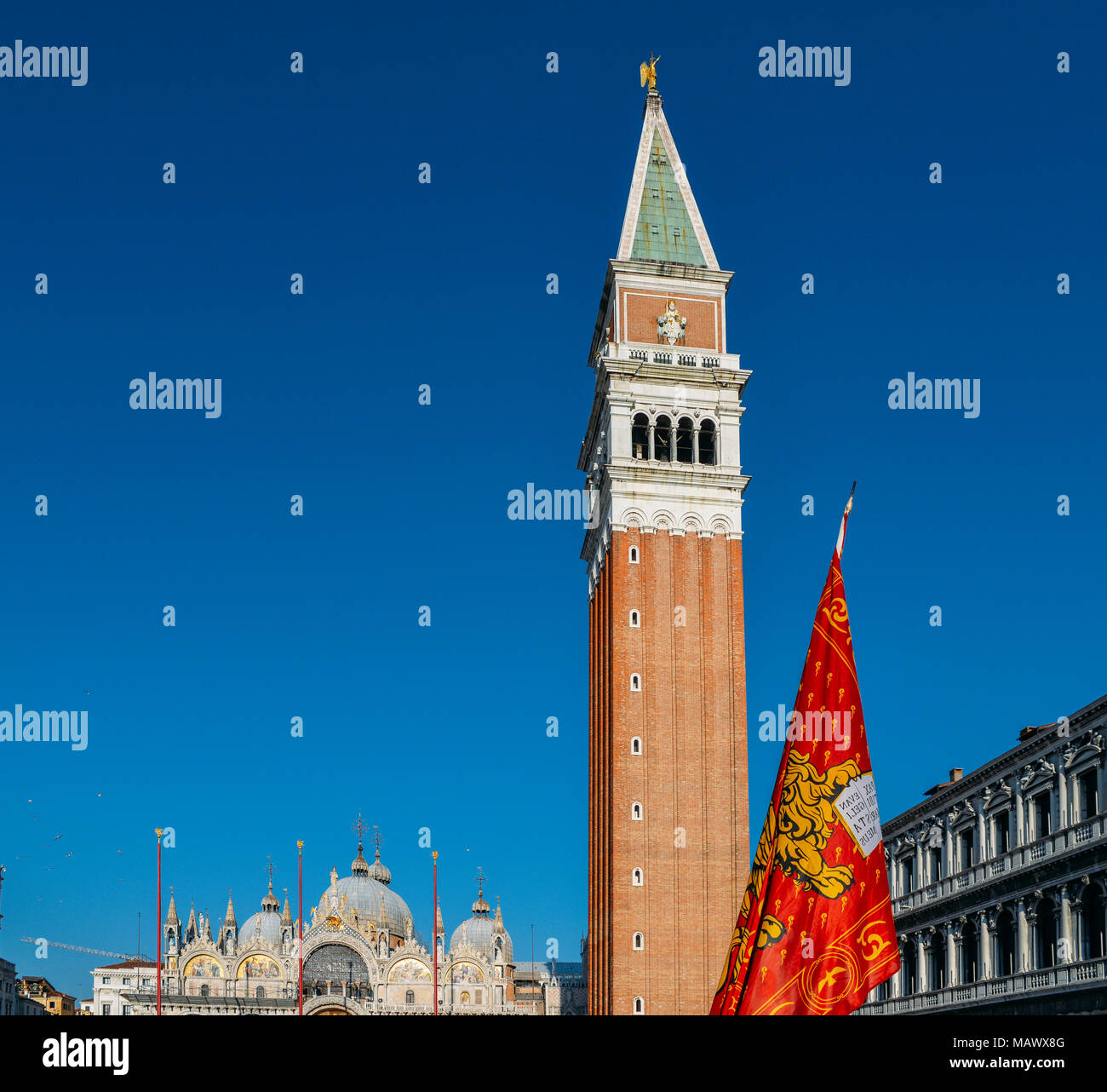 León alado de San Marcos de Venecia, la bandera en la plaza de San Marcos de Venecia con el Campanile de San Marcos torre. Foto de stock