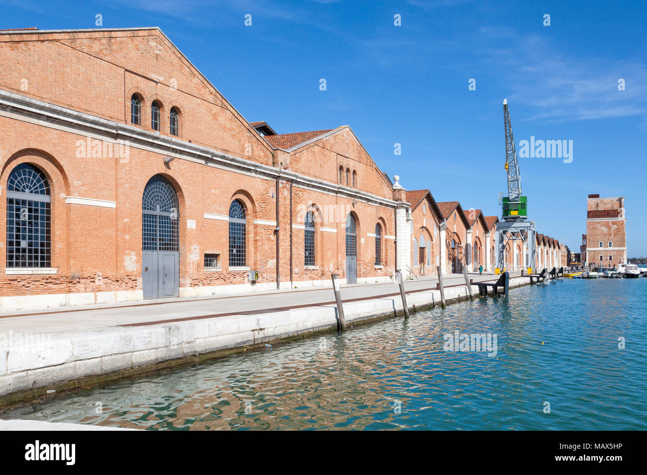 Antiguo astillero edificios en Darsena Nuovissima, Arsenale, Venecia, Véneto, Italia con la torre de Porta Nova ahora se utiliza como espacio de exposición de la bienal Foto de stock