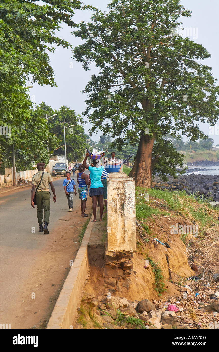 Una aldea de pescadores de Santo Tomé Street Scene, con mujeres que llevaban el pescado a casa y colegiales haciendo su camino a trabajar bajo la mirada de un soldado. Foto de stock