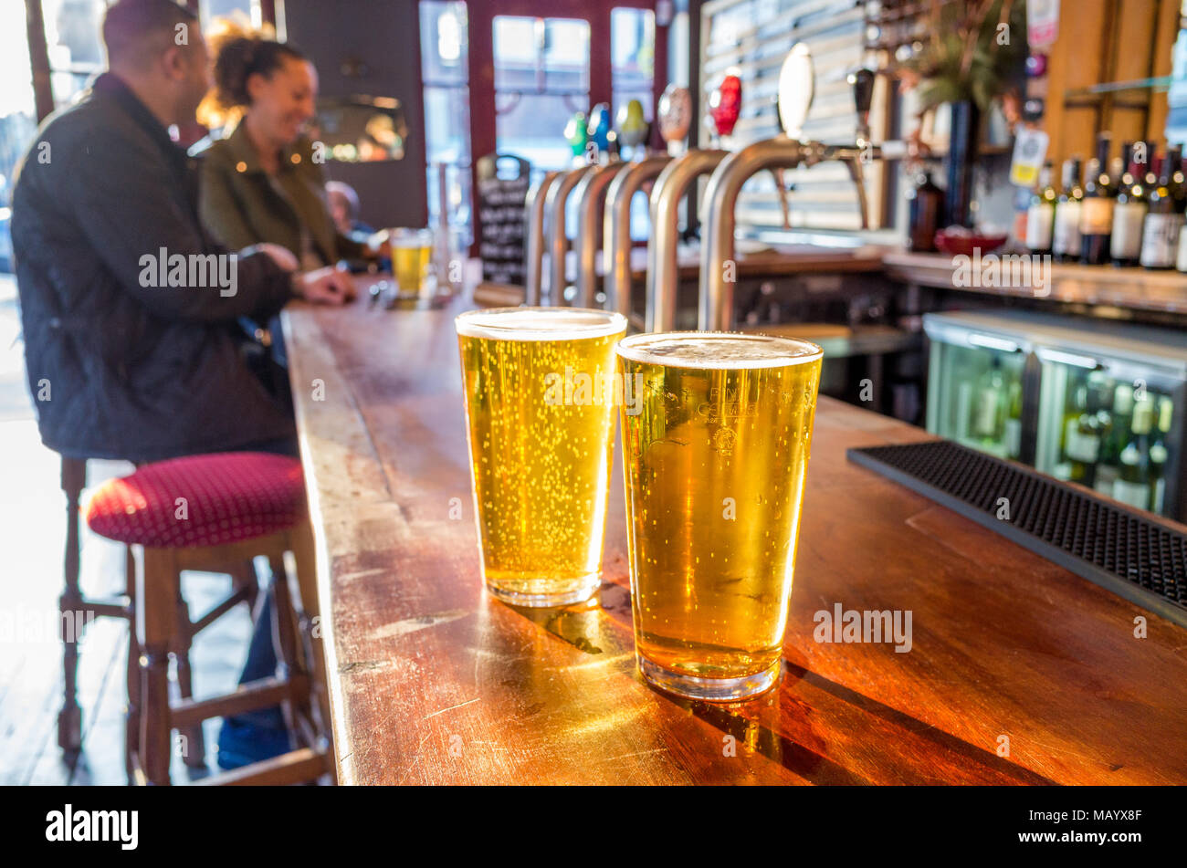 Cerca de dos pintas de cerveza en la barra de un bar, de Londres, Reino Unido Foto de stock