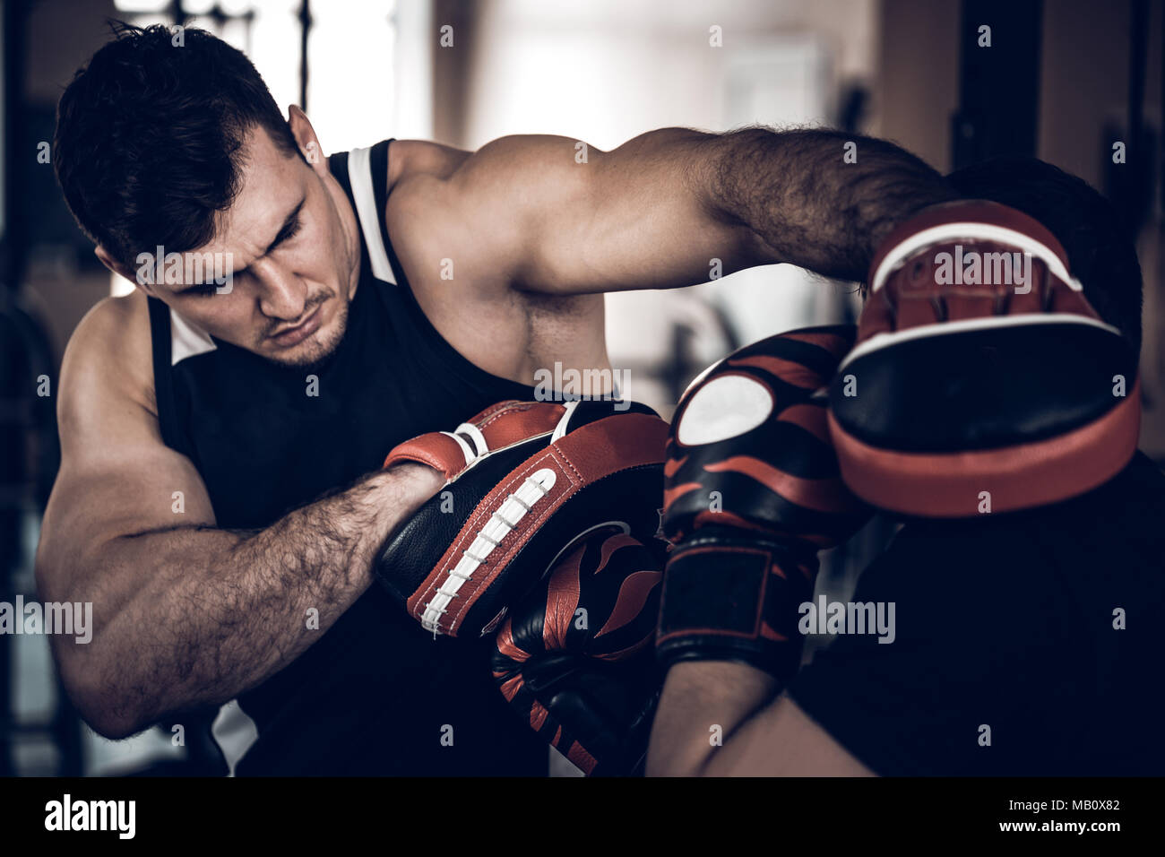 Entrenar con entrenador de boxeo y punzón manoplas Fotografía de stock -  Alamy