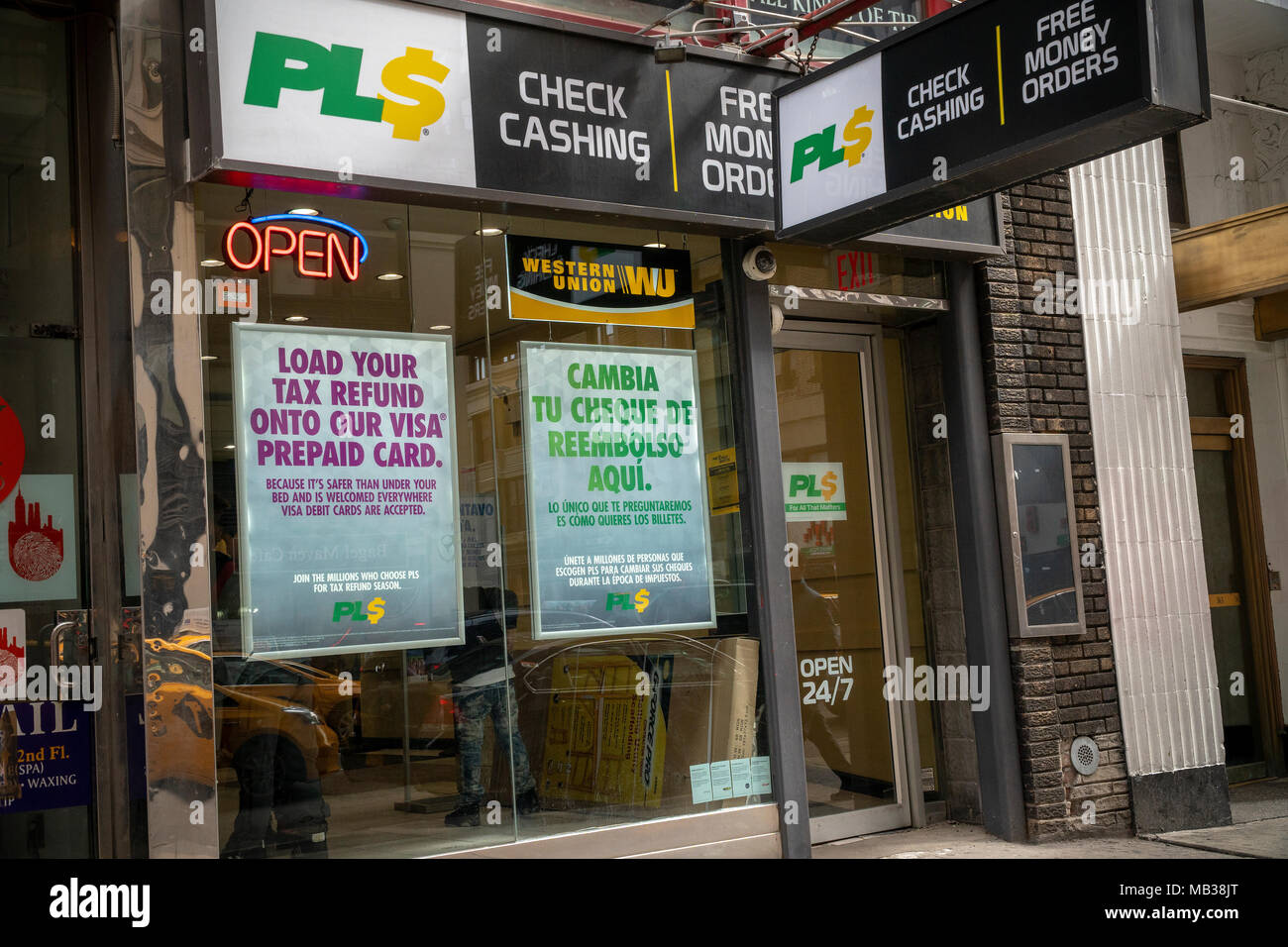 Un cheque de negocios en Nueva York anuncia en inglés y en español para que los clientes puedan poner sus reembolsos de impuestos en sus tarjetas de débito, visto el jueves, 5 de abril de 2018. (Â© Richard B. Levine) Foto de stock