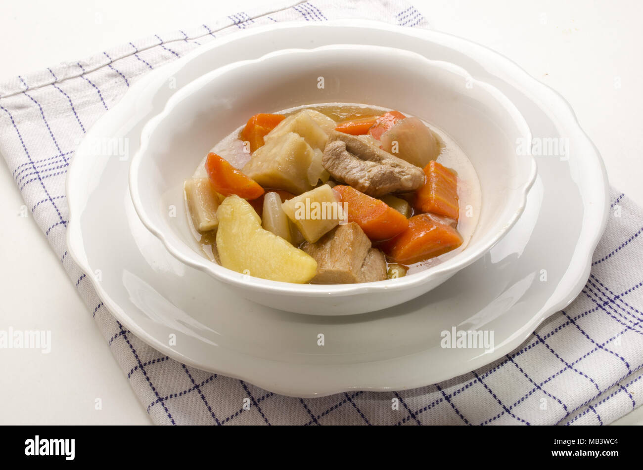 Hecho en casa clásico estofado irlandés en un recipiente blanco con vegetales growen inicio Foto de stock